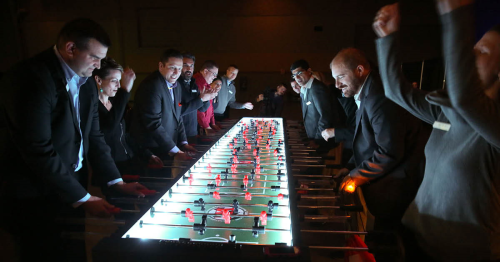 employees at event playing foosball